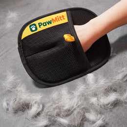 PawMitt glove on a hand above the loose fur it has just collected